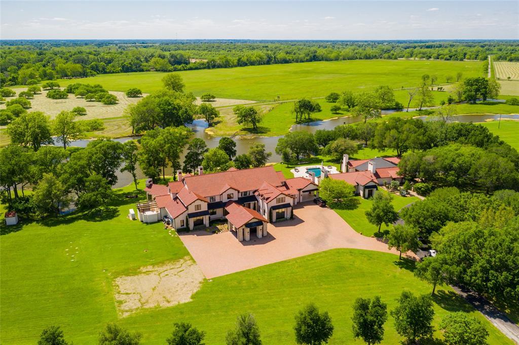 The incomparable Board Oaks Ranch in Hempstead, includes 1,305+/- acres of 3.5 miles of Brazos River frontage with beaches, ponds, 8+ acre stocked fishing lake, 5 water wells, improved/extensive open pastures and thick woods providing natural habitat for wildlife. Aerial view shows exquisitely appointed 4 bedroom/5 full bath/6 half baths main house, pool/hot tub/water features, remodeled 3 bedroom/3 bath guesthouse, barndominium, 8 stall horse barn and so much more!