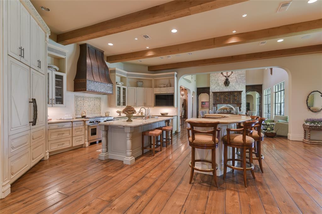 Shown here is the KITCHEN and two CENTER ISLANDS - wide planked hardwood flooring, 12 foot ceiling with exposed wood beams, recessed lighting,  wood cabinets/drawers, stone counter-tops with decorative stone backsplash, top of the line appliances!