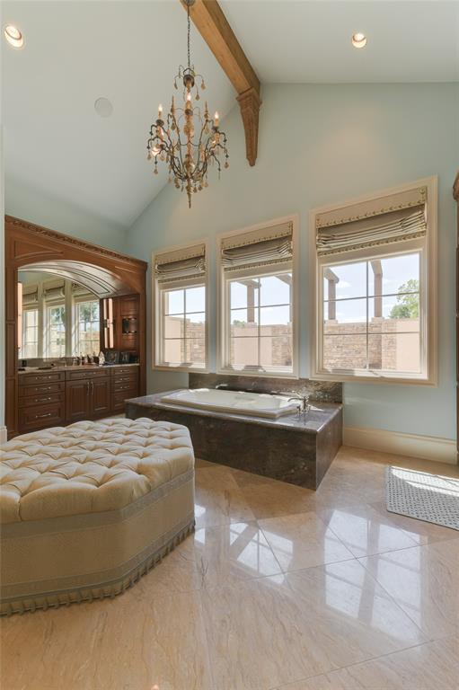 Exquisite describes the PRIMARY BATH (23 X 21) with its marble tile flooring, granite counters/backsplash, dual sinks with cabinets below, vanity seating, two TV niches, mirrors with built-in light sconces, Bain Ultra spa tub (granite surround) with three mullioned windows (shades overlooking private patio), pitched ceiling with exposed wood beam/recessed lighting/hanging chandelier, two private water closets, glass front walk-in steam shower with stone surround, spacious dual clothing closets.