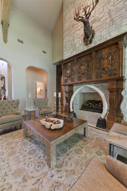 A closer view of the centrally located gas log FIREPLACE with its intricately and masterfully carved wood surround and mantle.