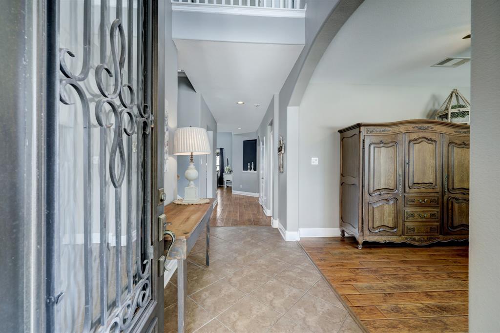 Grand entry with soaring ceiling and rich hardwood flooring.