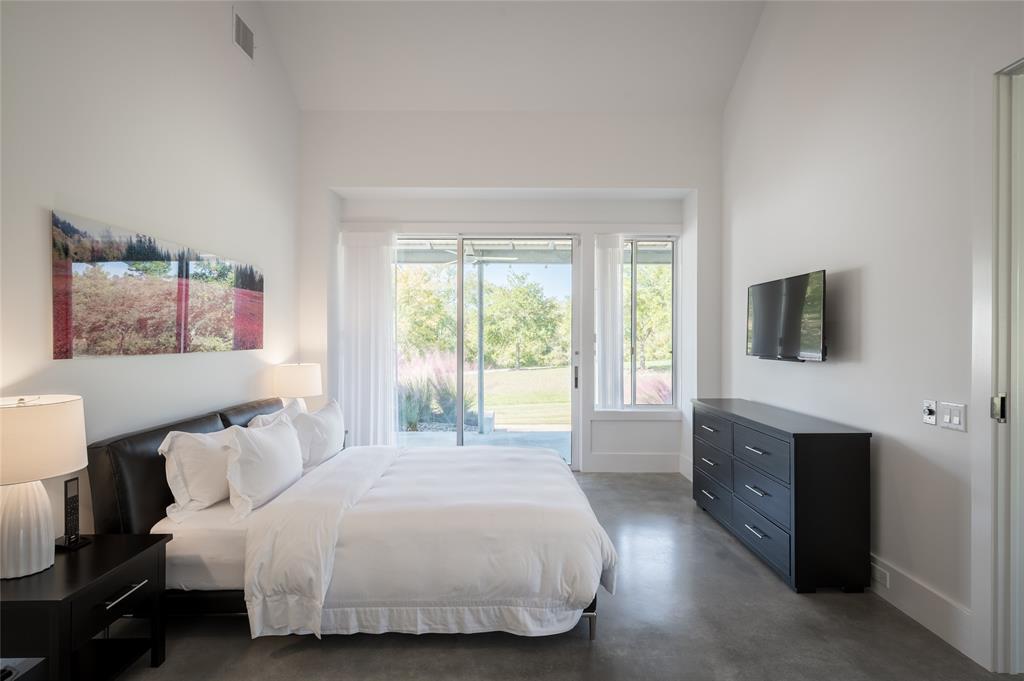 The guest house bedroom one includes oversized sliding glass doors leading to the  back covered patio area