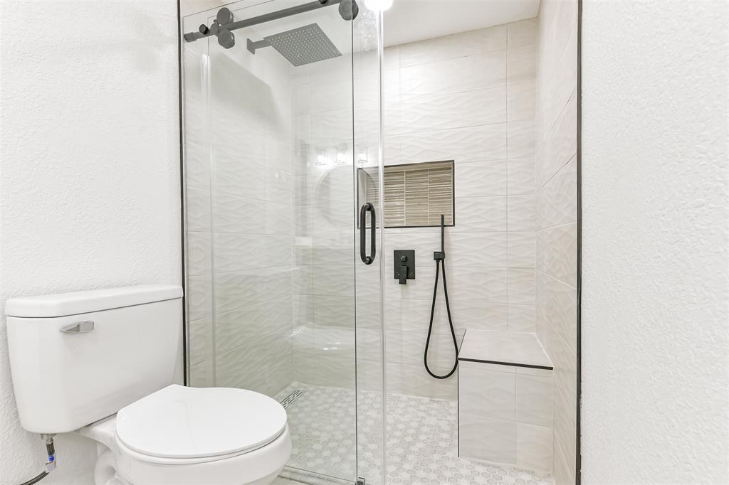 Primary curbless shower with built in bench, soap box, rain and body shower head
