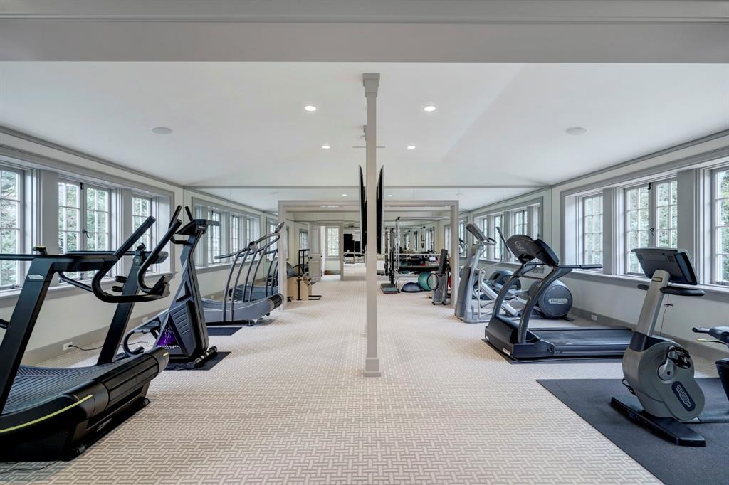 The Exercise Room. Located on the second level over 4-car garage with lots of natural light. Doorway at end of this room opens into a private Massage Room.