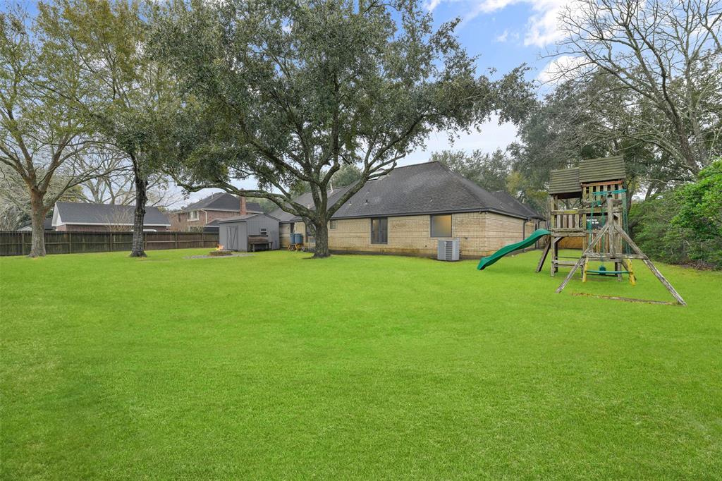 In the backyard, you'll find a pair of sprawling shade trees, a brick paver fire pit, an included child's playset, a storage shed, and a double gate opening onto Sunset Drive. With no HOA dues or restrictions here, you can dream big to make this the backyard of your dreams!
