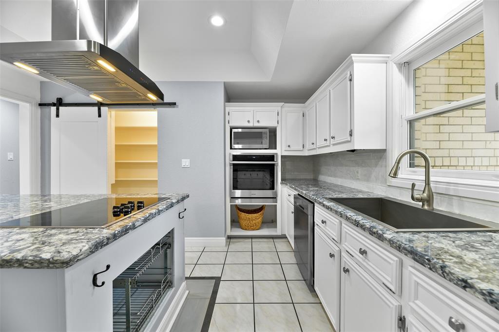 The cook of the family is sure to appreciate the updated stainless appliances that include a smooth glass cooktop with a modern vent hood, a new Samsung oven, a space for a microwave, a concealed control dishwasher, and a deep single basin sink with a gooseneck faucet.