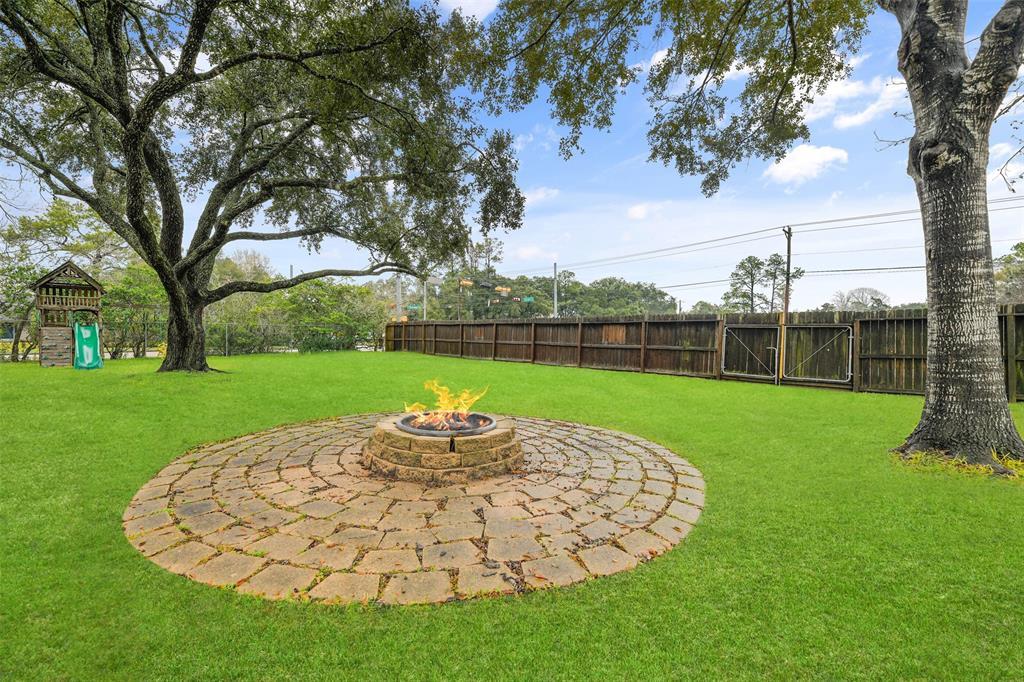 In the backyard, you'll find a pair of sprawling shade trees, a brick paver fire pit, an included child's playset, a storage shed, and a double gate opening onto Sunset Drive. With no HOA dues or restrictions here, you can dream big to make this the backyard of your dreams!