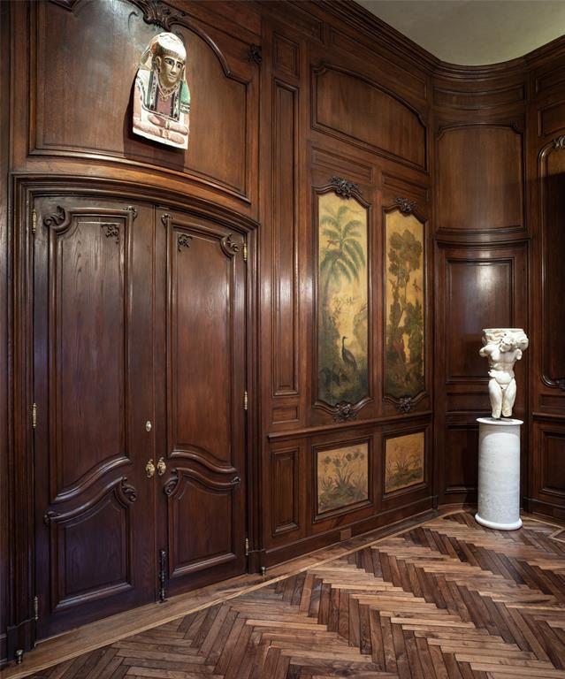 The Library features handsome antique mahogany paneling with inset painting of pastoral scenes.