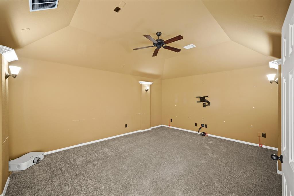 The media room has a high ceiling with ceiling fan, faux columns with wall sconce lighting & carpet. Included is pre-wiring for surround sound speakers & wall mount with wiring for a flat screen TV. As an added bonus, a movie projector is included.