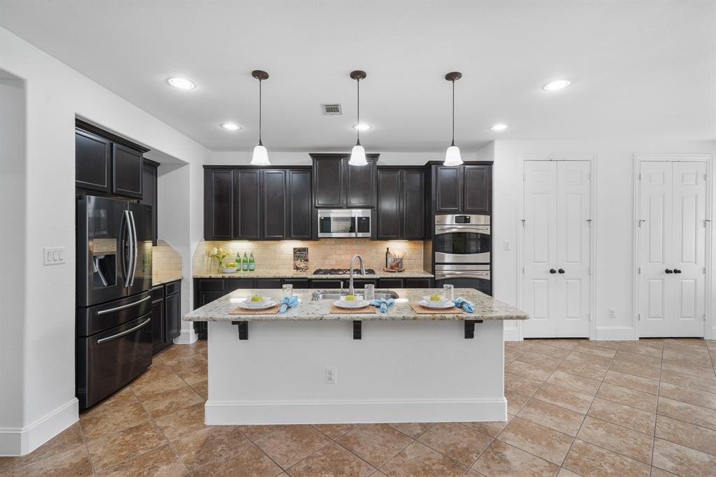 A gourmet kitchen awaits you! Features include recessed lighting, 42" wood-stained cabinetry capped with crown moulding, granite counter tops highlighted by a tiled back splash with under-cabinet lighting & tile flooring.