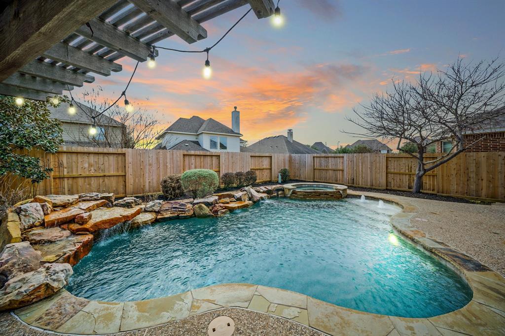 Enjoy resort-style living in this fabulous backyard with a free-form pebble surfaced & heated swimming pool, tanning ledge, rock waterfall and an elevated hot tub with cascading waterfall surrounded by flagstone coping.