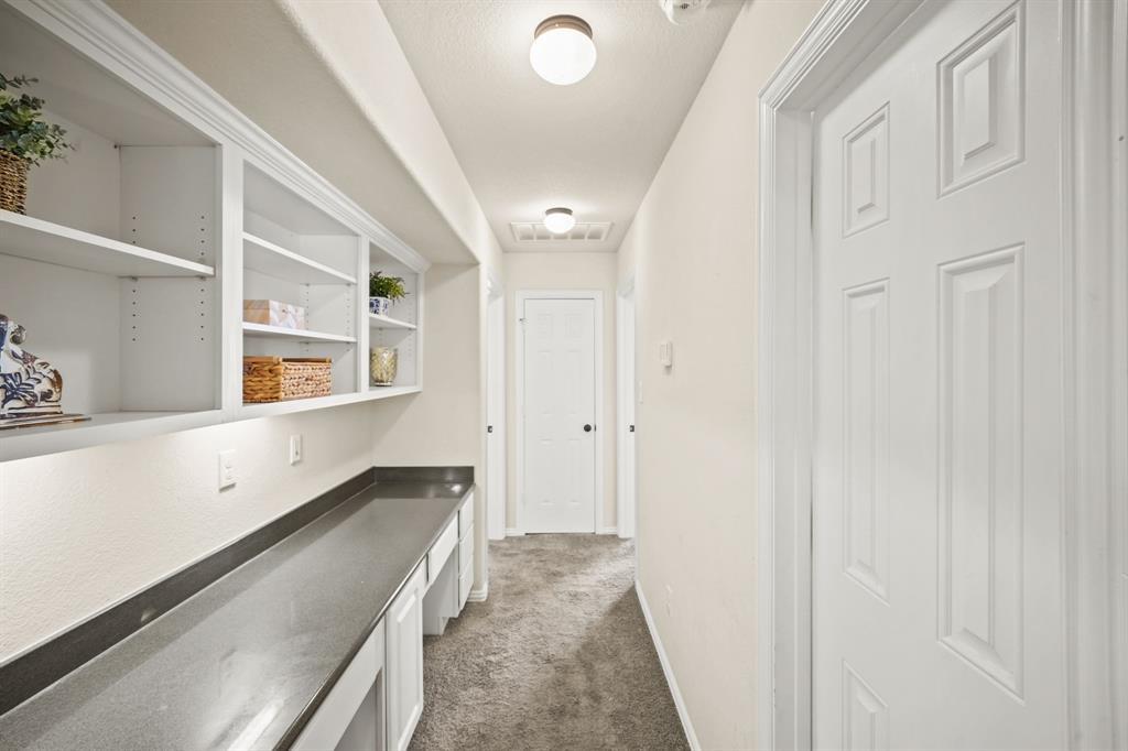 The second floor corridor includes a built-in study area with upper shelf storage, a granite surfaced built-in desk for two and a storage closet with shelving.