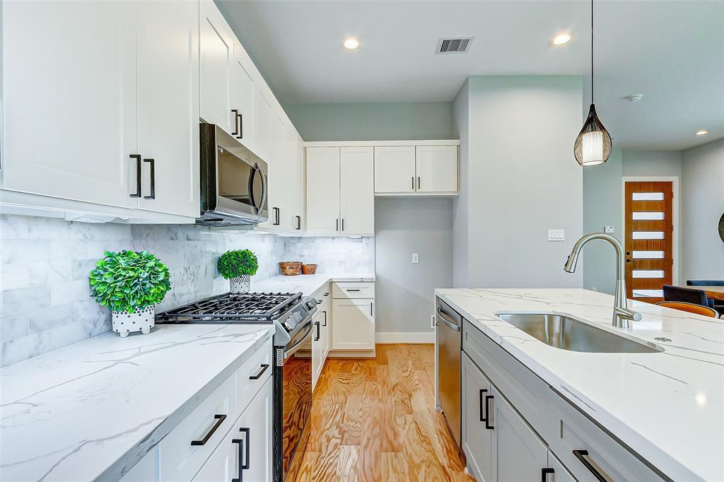 Equipped with Samsung appliances, Moen fixtures, quartz waterfall countertop and ample cabinet space.