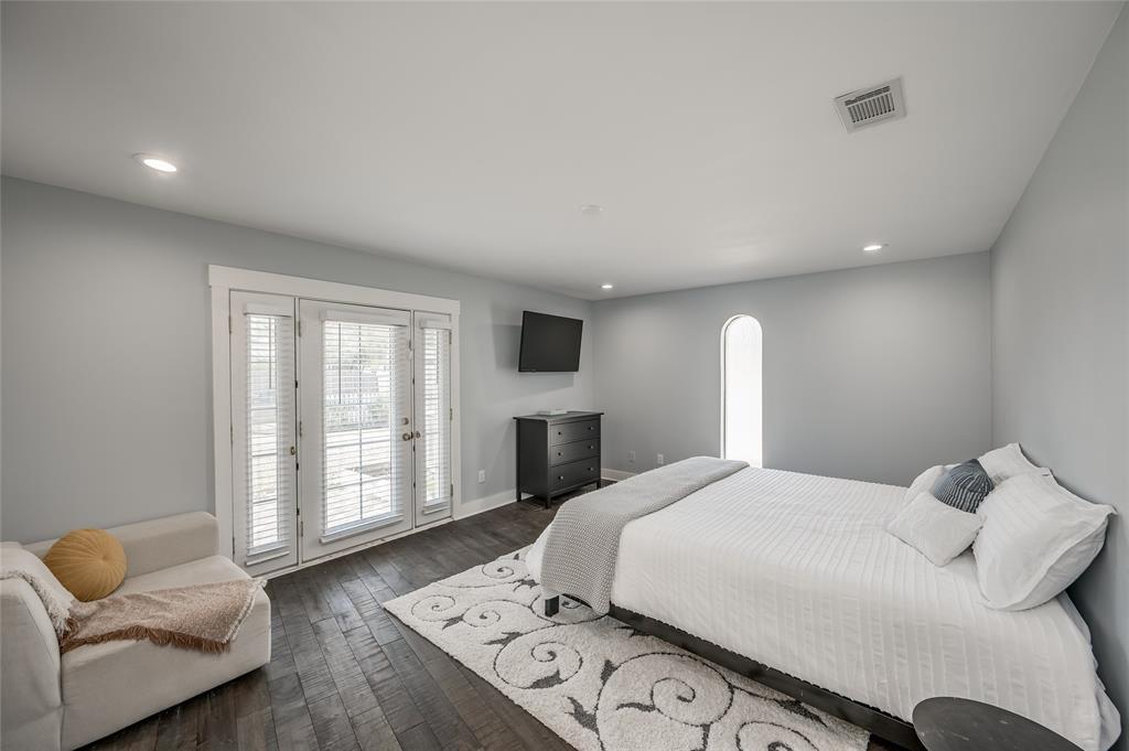 One of two owners suites. This bedroom is located near the front of the home and features an en suite bathroom, walk-in closet, and private entrance to the patio and backyard.