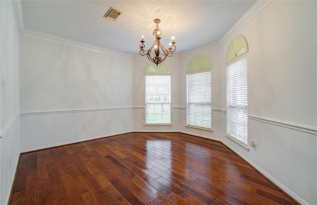 Elegant formal dining room with beautiful chandler, crown molding and hardwood floors.