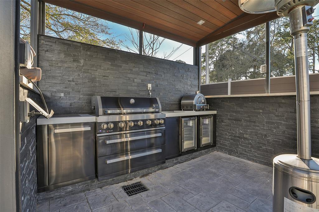 The stately outdoor kitchen comprises state of the art grill, pizza oven and refrigerator for BBQ's galore. Note the stack stone and IPE accents.