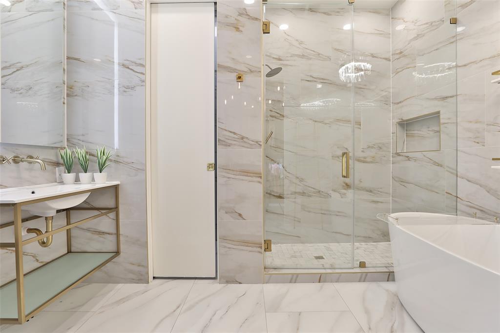 "Her" bathroom suite exudes femininity with floor to ceiling elegance magnum polished 32x32 tiles and champagne gold accents.