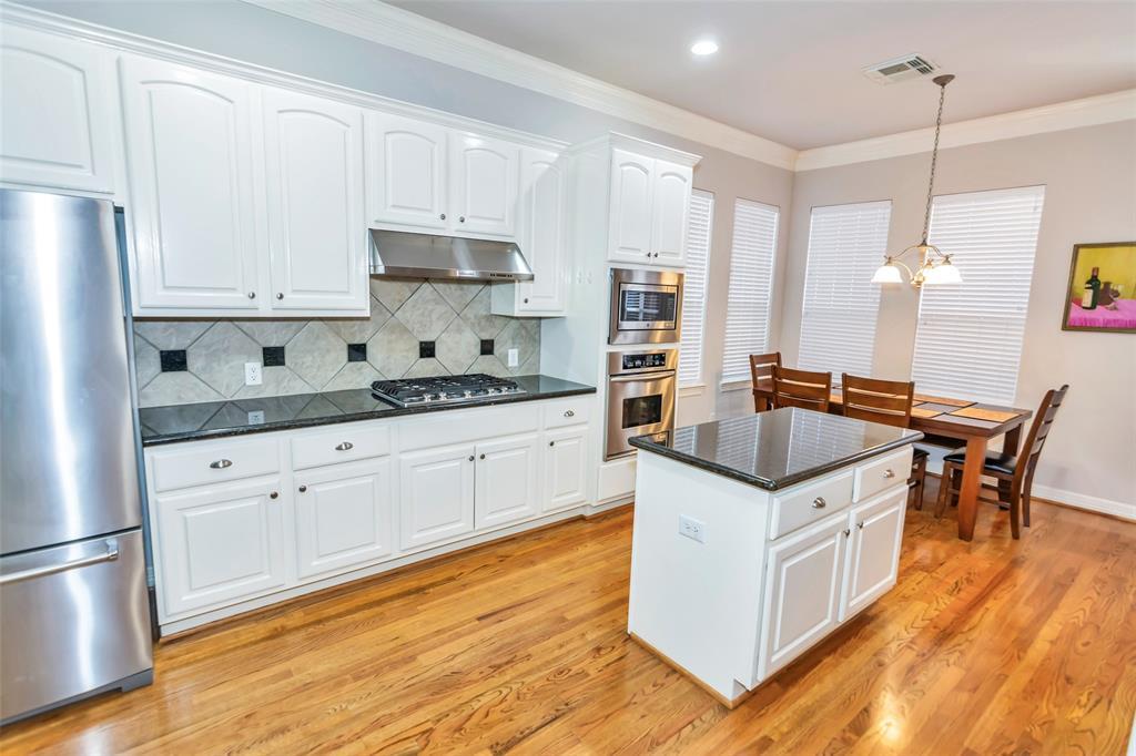 Grand kitchen with granite countertops, tile backsplash with granite insets.