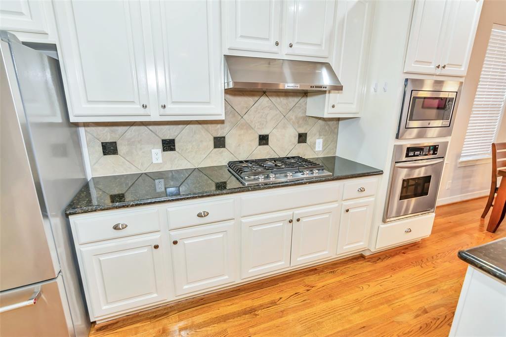 Gas cooktop with oversized stainless steel vent-a-hood.