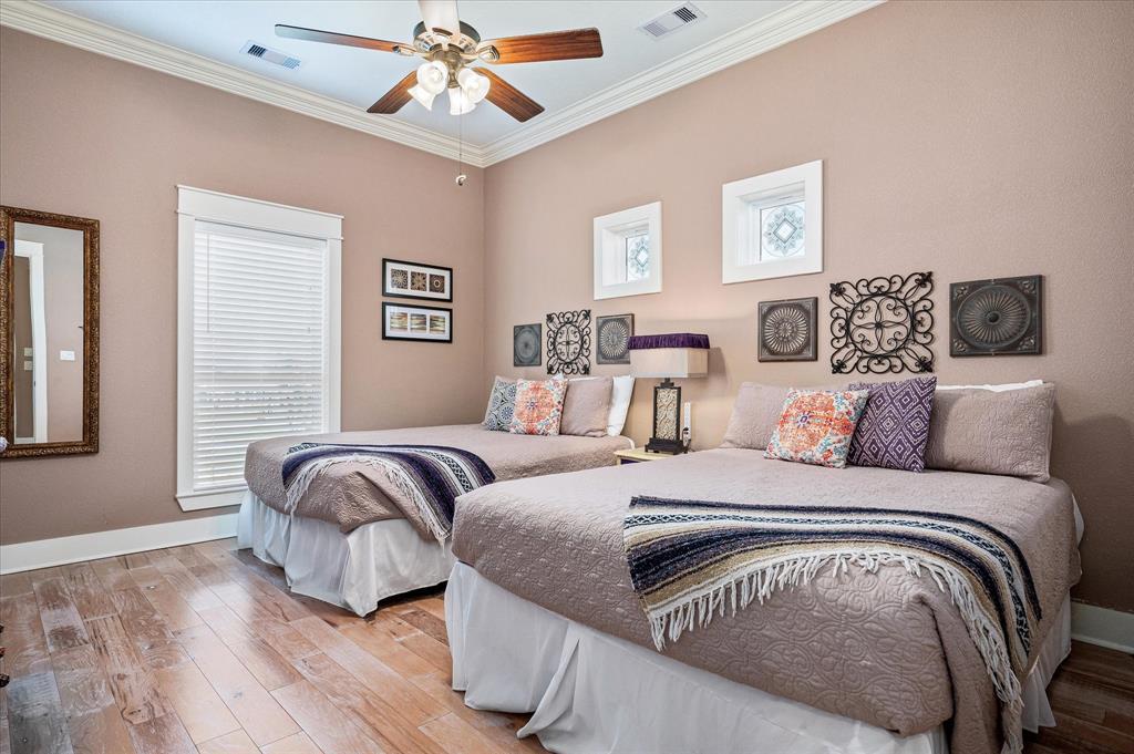 There is enough room for two queen bed in this secondary bedroom with ceiling fan and charming windows.