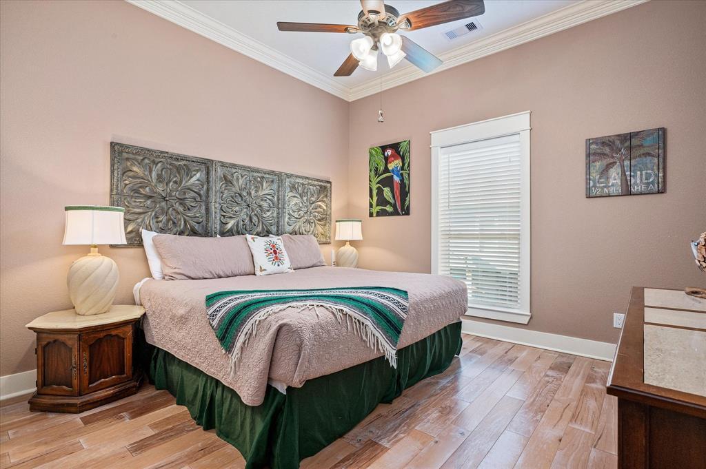 A spacious secondary bedroom with king-sized bed and ceiling fan.
