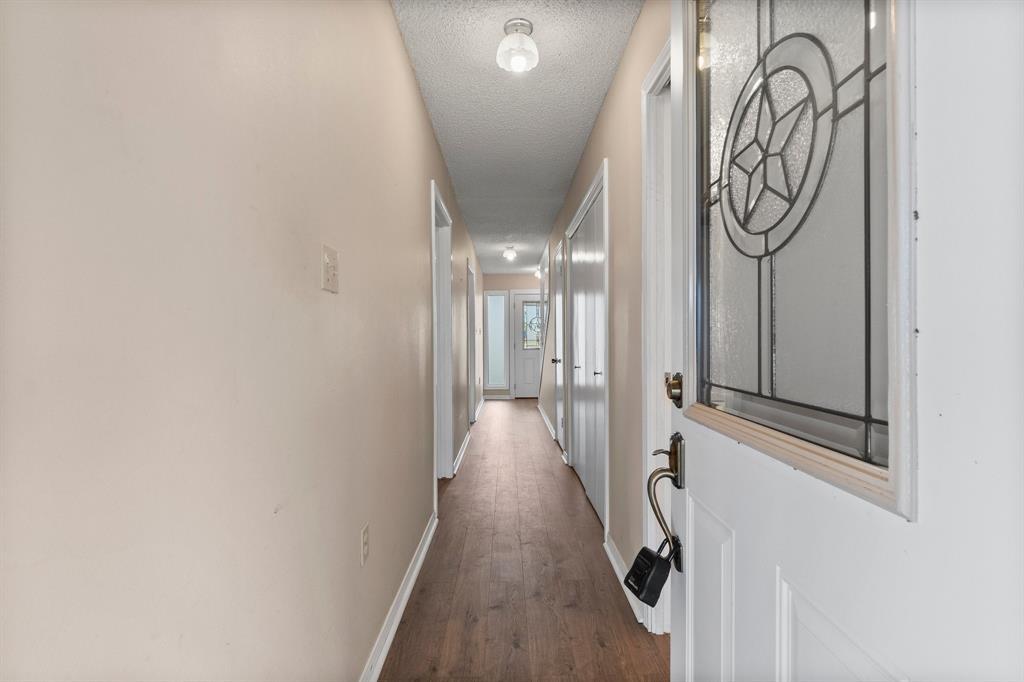 Enter the front door to access the guest bath, 2 bedrooms (either of which could be an office), interior garage access and staircase to enter access to upstairs and balcony.