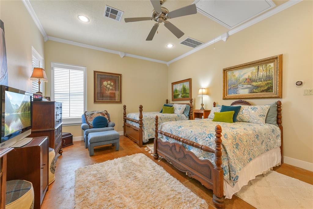 On a separate zone of HVAC, the pool house guest suite is plenty large for double beds and other large pieces of furniture.  The flooring is stained concrete.  Above are crown moldings.  A perfectly self contained and comfortable place to stay.