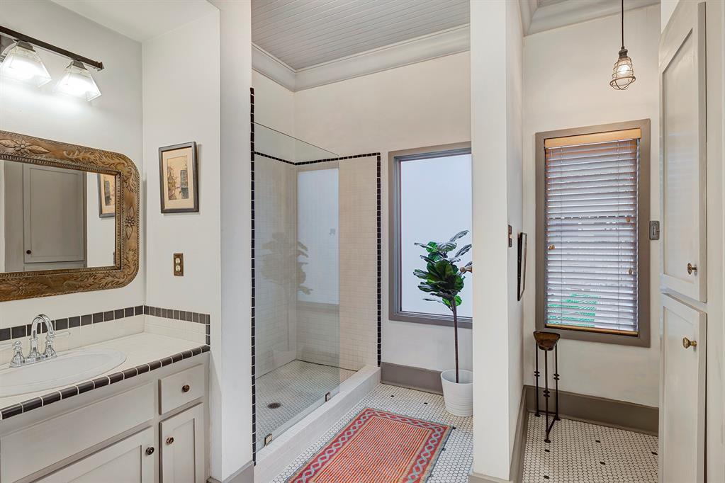 Beautiful primary bathroom is well-appointed with vintage tile counters, double sinks, nice lighting and walk-in shower.