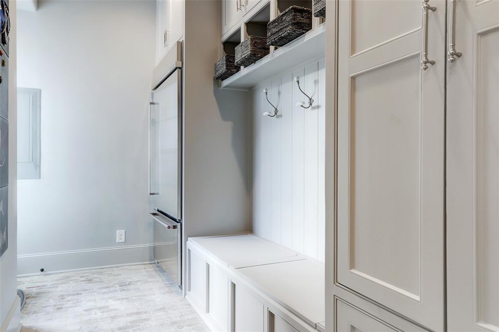 Fabulous mudroom has hooks, cabinets, storage under the bench and refrigerator.