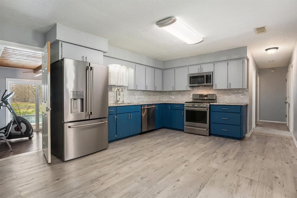 Open kitchen with handmade cabinets, granite counters, stainelss steel appliances and recently replaced flooring.