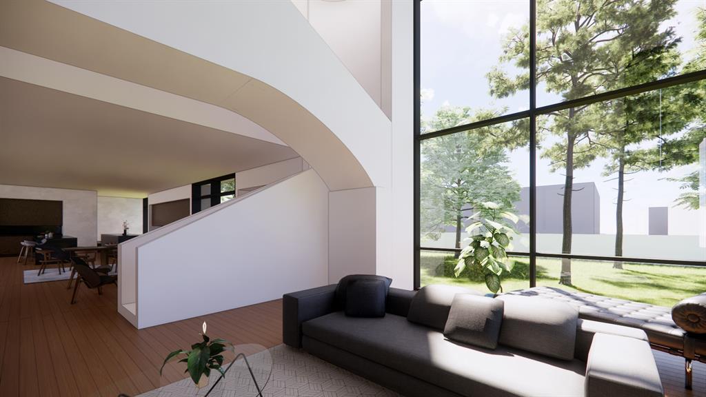 Airy and bright interior space within a modern home, featuring an elegant curved staircase and large floor-to-ceiling windows that offer an expansive view of the outside greenery.