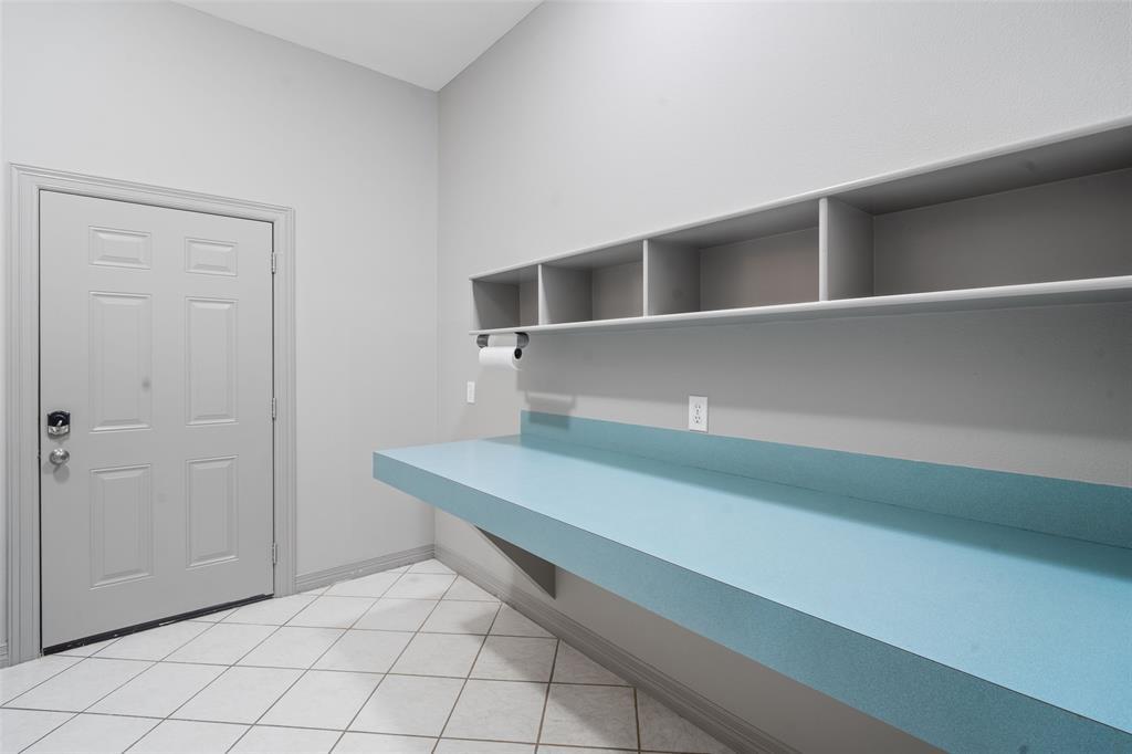 The utility room is large and features a table for folding clothes. It also provides plenty of storage space and leads to an oversized 3-car garage that can easily accommodate a full-size pickup truck while still leaving room to work.