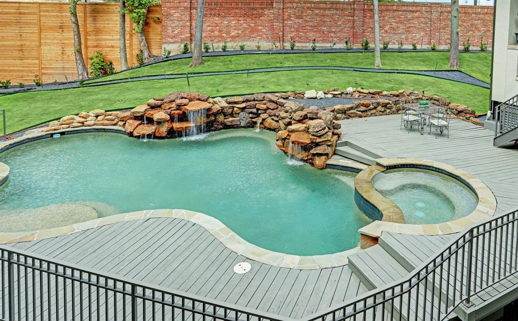 The inviting pool features a peaceful water fall and a large spa.