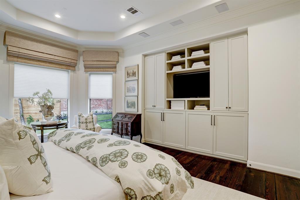 An alternate view of the primary bedroom highlighting the custom built-ins.