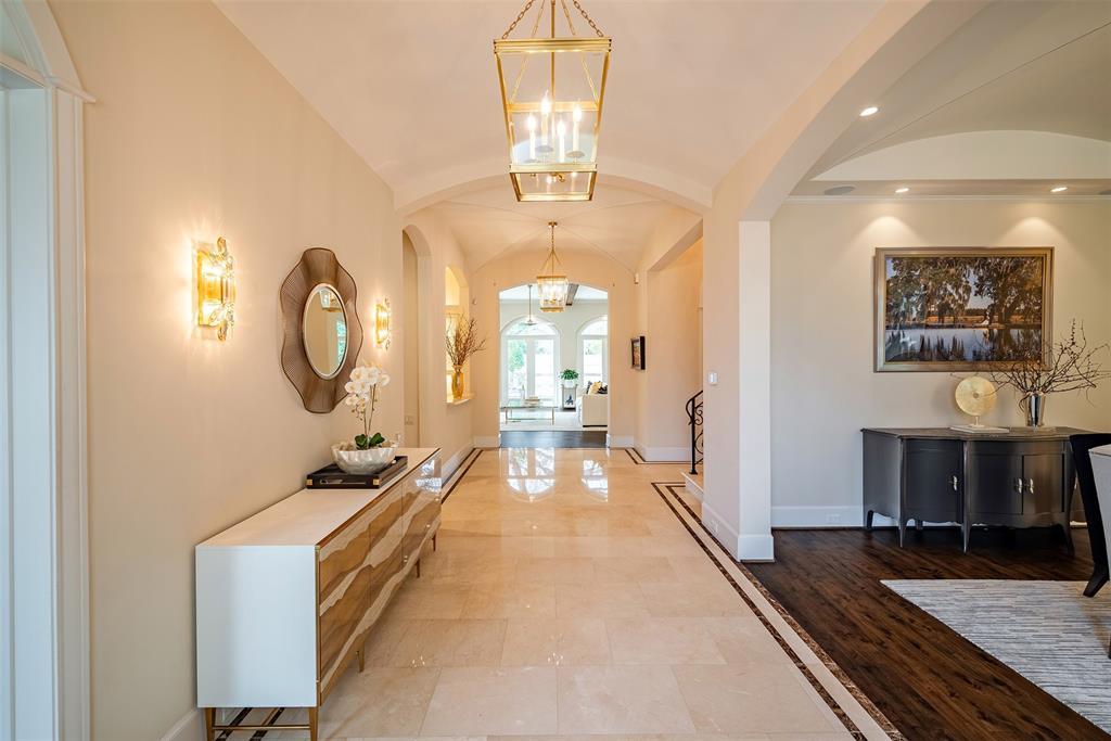 Beautiful foyer leads your way with all beautiful arches and gorgeous details. The study with the double French door & the elevator is next to the bar area to the left off the foyer.