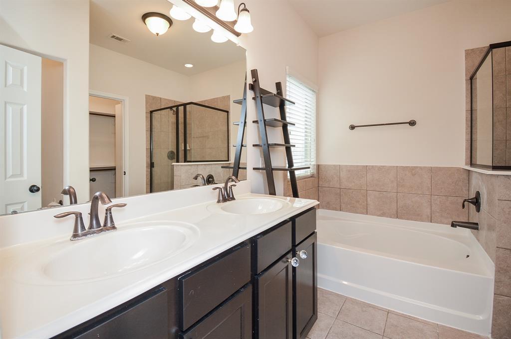 The dark/light contrast is striking in your primary ensuite bath, with dual sinks, wall wide mirror and the comfort and convenience of a lush soaking tub, right next to your walk-in, glass enclosed shower.