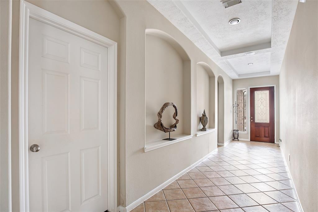 Other end of the long entryway shows plenty of natural light, and neutral Earth tones throughout.
