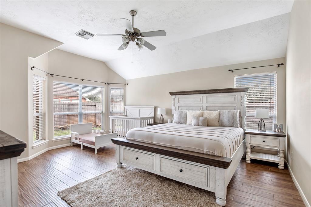 Step into this Woods-style Tiled Primary Bedroom, Boasting with Vaulted ceilings, and windows galore. This updated flooring was completed in 2021, and adds a nice touch to this spacious Primary Room!