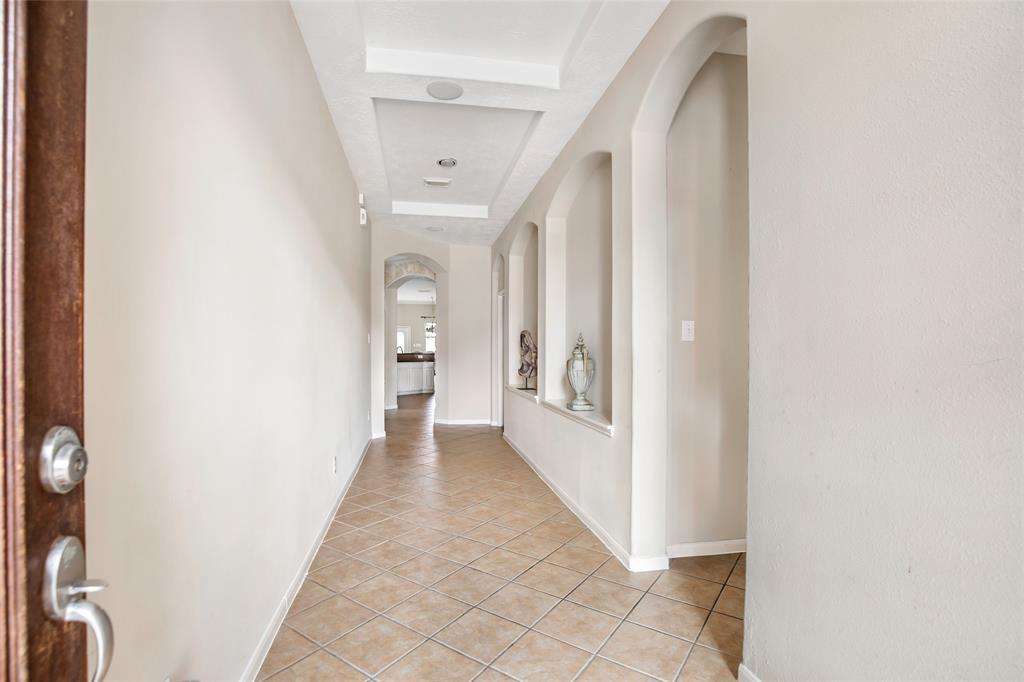 Upon entering, notice this Over-sized Tiled Entry Foyer, with Beautiful Architecture, Lovely Art-Niches, and recessed Lighting, and ceramic tile flooring leading to the Living Areas.