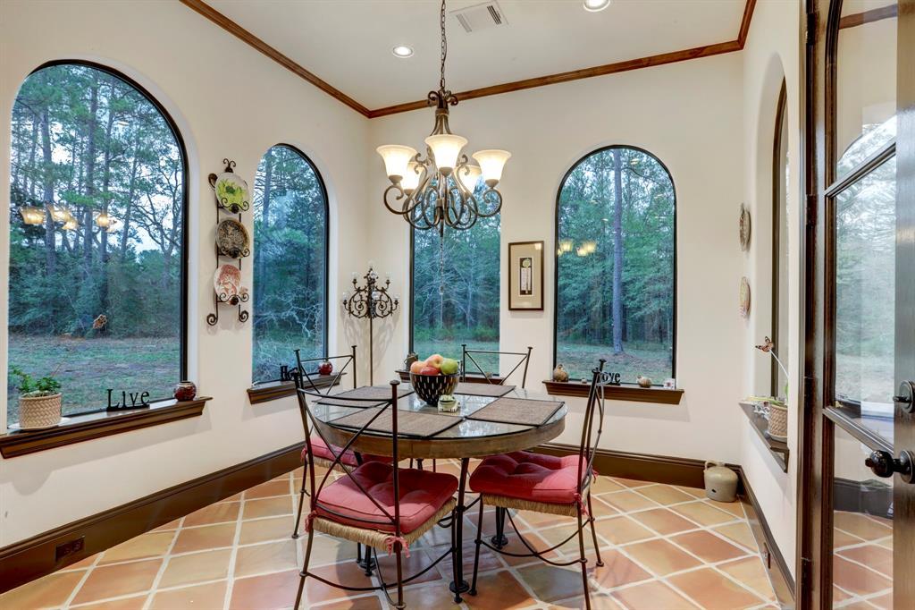 Dine in elegance in this charming area framed by large arched windows offering panoramic views of the surrounding forest. The space is bathed in natural light, enhancing the warm terracotta tiles and wooden accents. It's an idyllic spot for enjoying meals and the beauty of nature simultaneously.