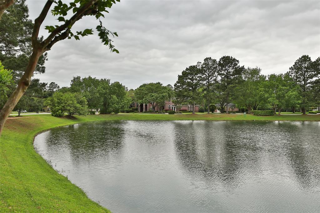 View of this impressive property as seen from across the beautiful lake featured within the community.