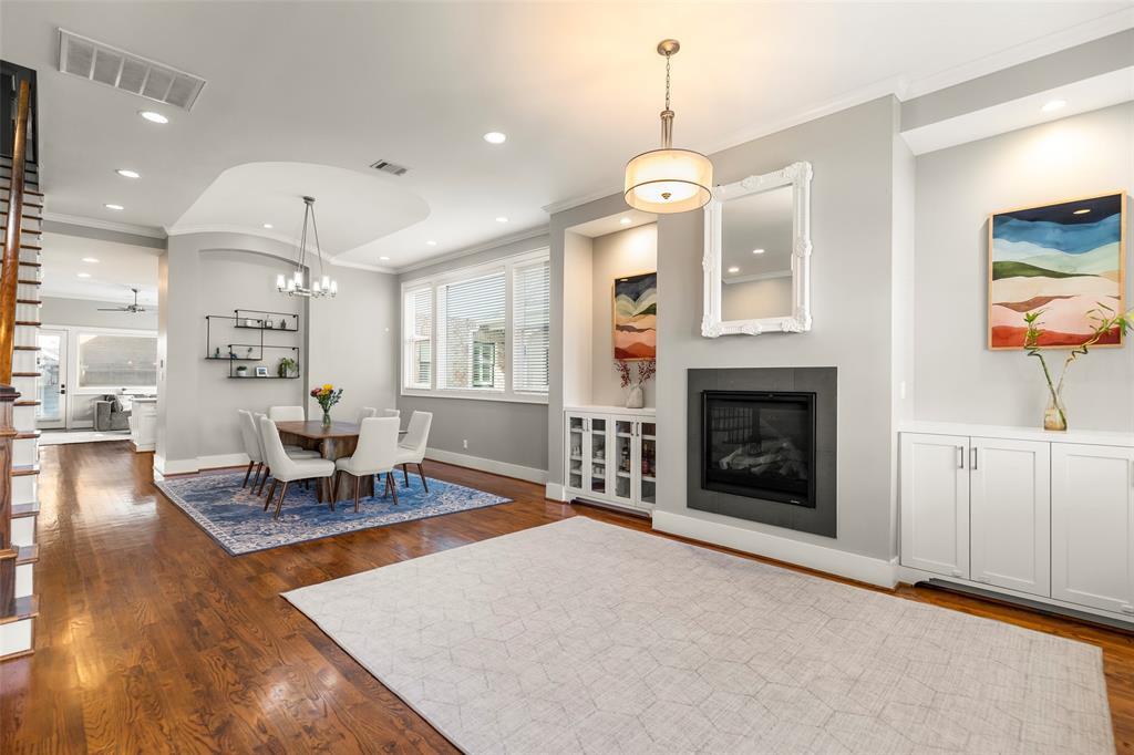 A view of the open concept living and dining room. Features include recessed LED can lighting,  baseboards & crown molding. The hallway leads you back to the powder room, kitchen, family room, and back patio/backyard.