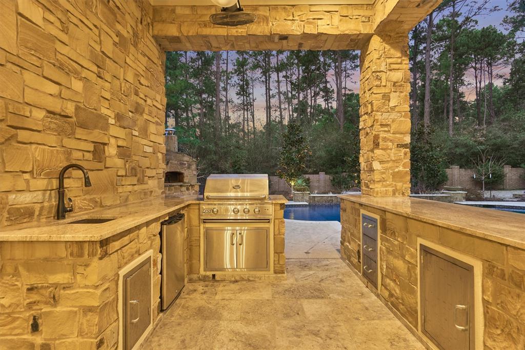 Outdoor kitchen for year round outdoor grilling and entertaining. The outdoor cooking area boasts plenty of counter space and a convenient sink for all of your culinary needs.