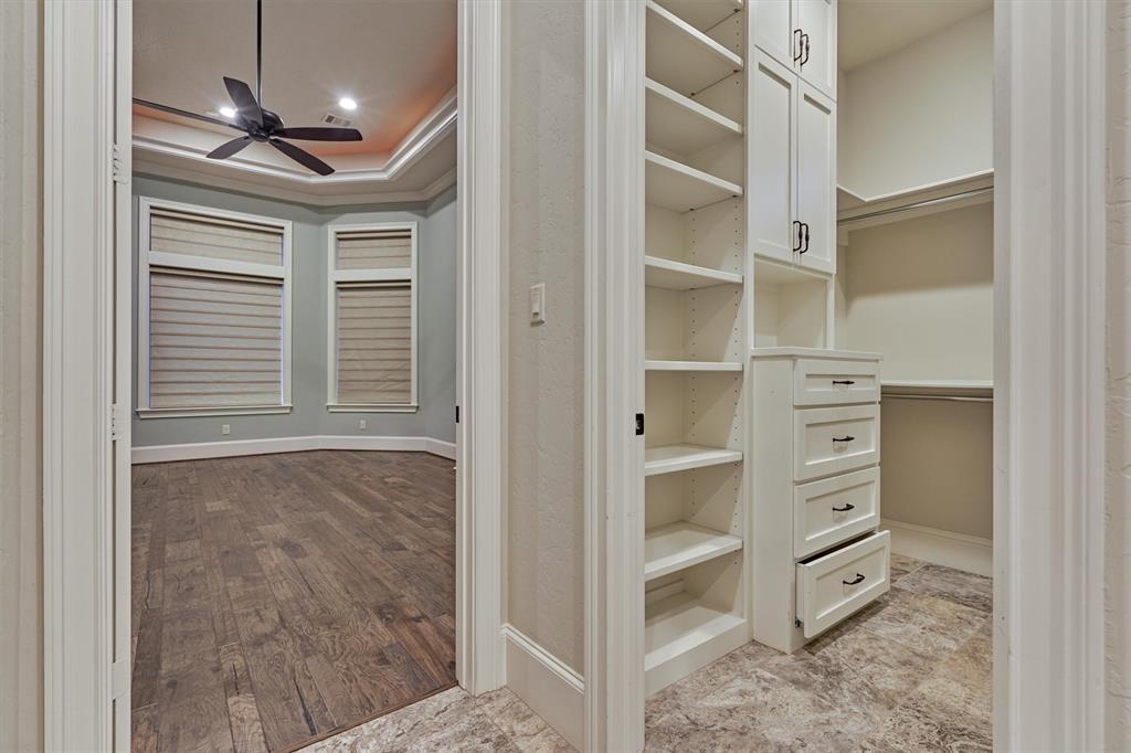 The primary closet features an abundance of custom built-ins for storage.