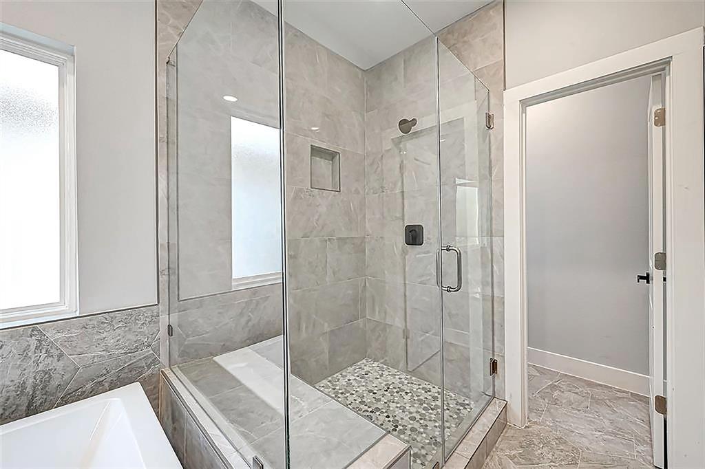 Separate sizable shower with a bench. Interior photos are from another community by the same builder; finishes and selection may vary.