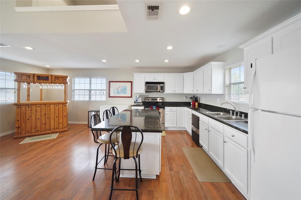 Kitchen with granite counters, freshly painted cabinetry, under-counter ice maker, and stainless steel appliances.