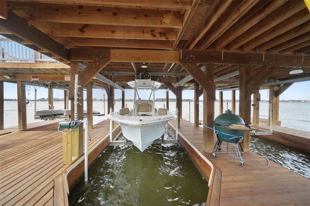 Below the house is complete with 2 boat lifts (5,000 pounds and 10,000 pounds), 2 jet ski lifts, and covered decking.