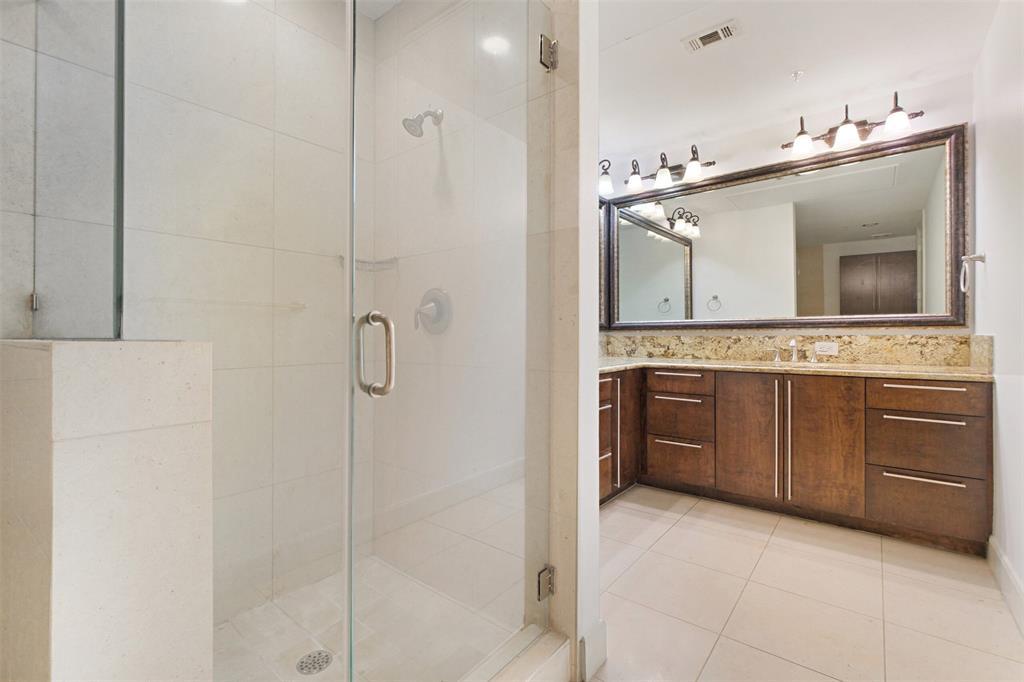 The primary bathroom offers a seamless-glass shower and garden tub.