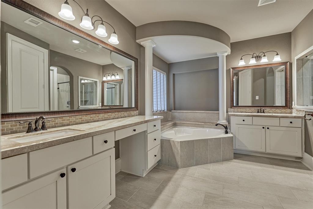Spa-like primary bath features dual raised vanities with attractive oil-rubbed bronze fixtures, and oversized soaking tub.  Note the makeup/prep station makes getting ready in the morning a breeze!
