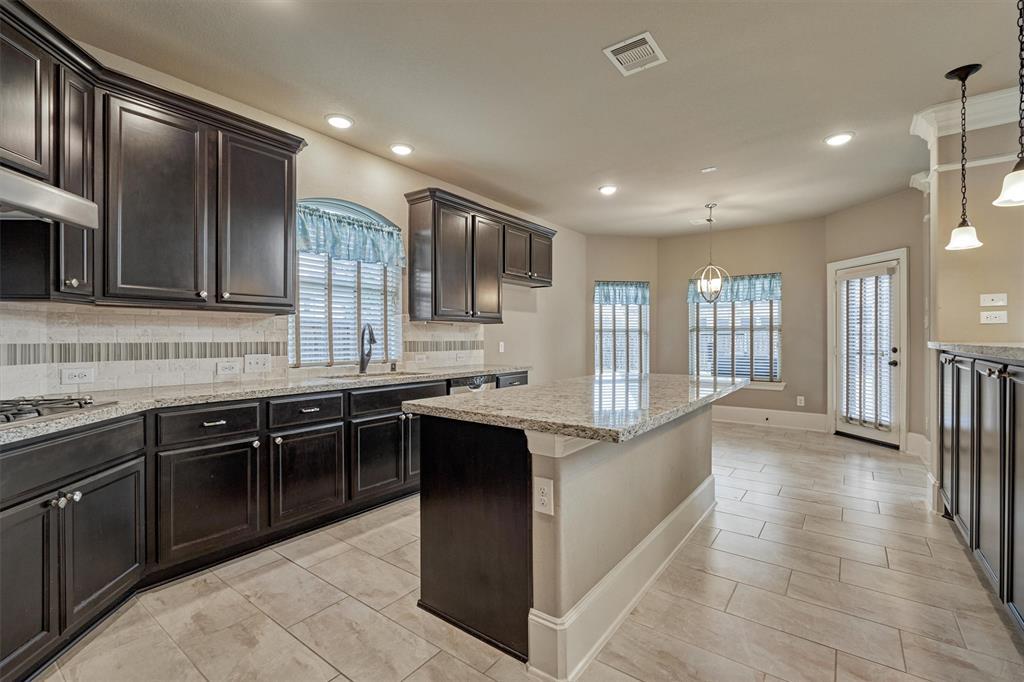 Spacious kitchen features Kent Moore cabinets, gas cooktop and tumbled stone backsplash.
